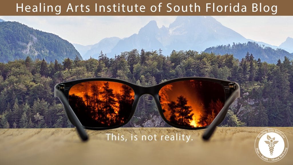 A pair of glasses overlooking a serene mountain forest. A forest fire can be seen through the lenses.